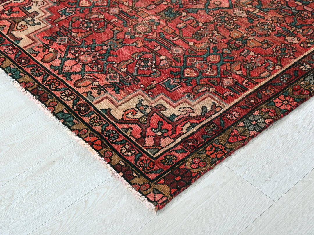 a red oriental rug on a white wooden floor