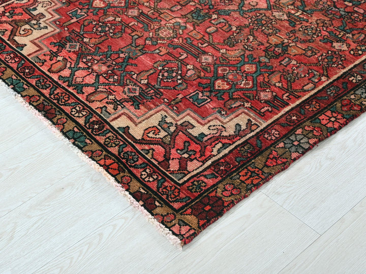 a red oriental rug on a white wooden floor