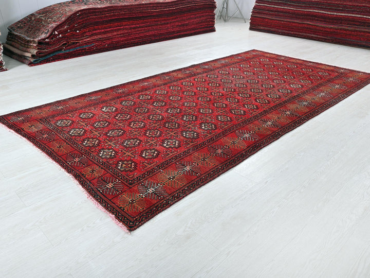 a pile of red rugs sitting on top of a white floor