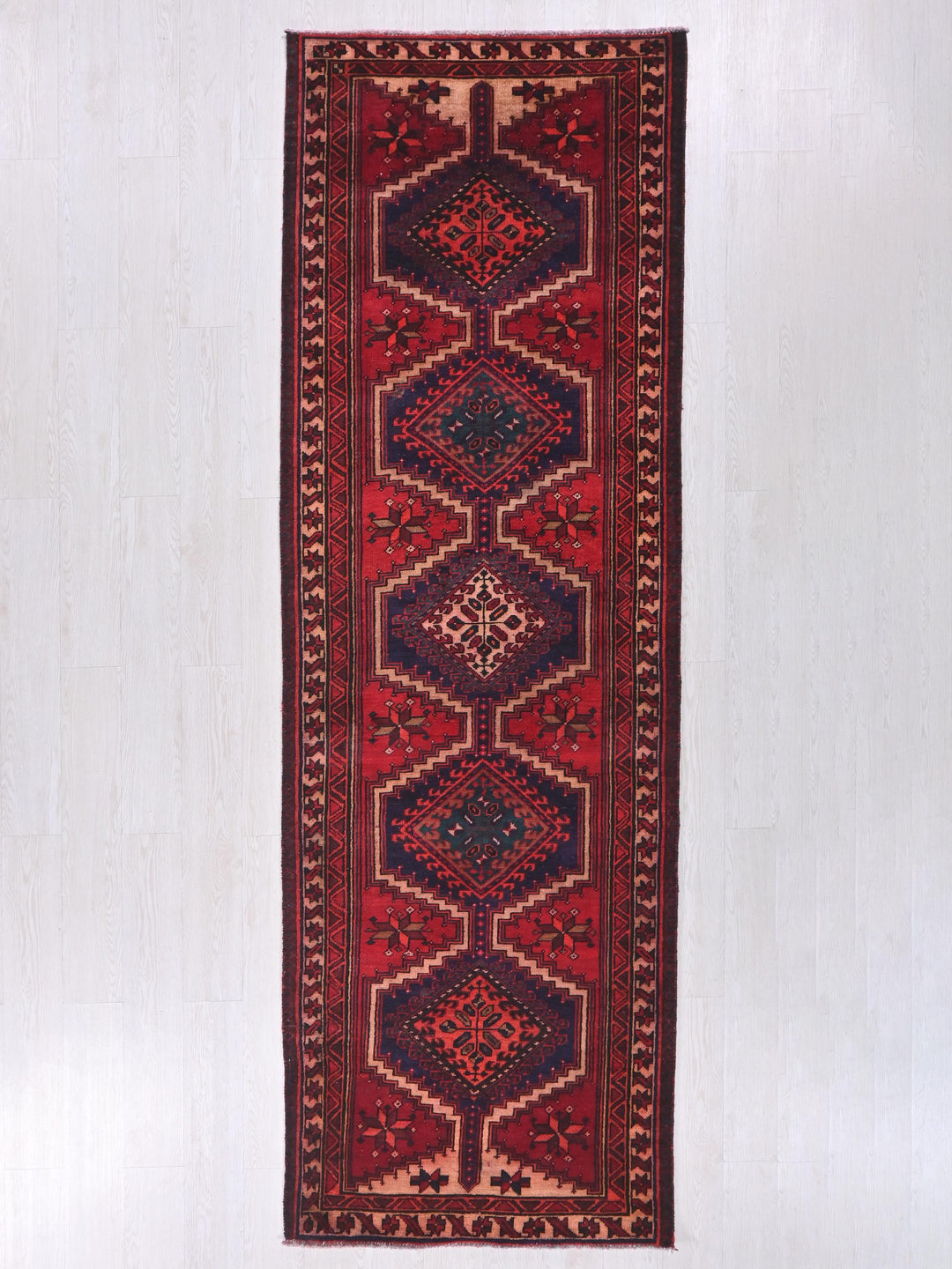 a red and blue rug hanging on a wall