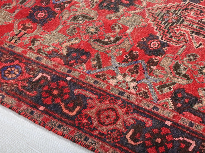 a close up of a red rug on a wooden floor