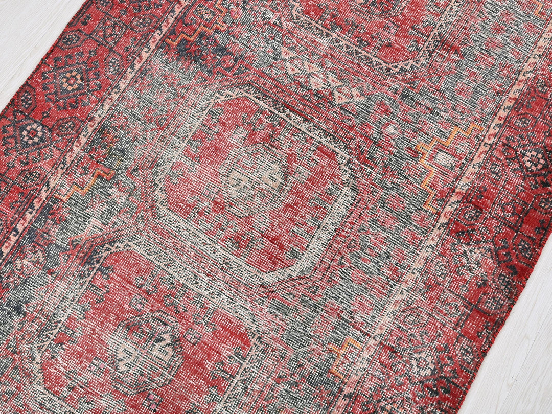 a red and gray rug on a wooden floor