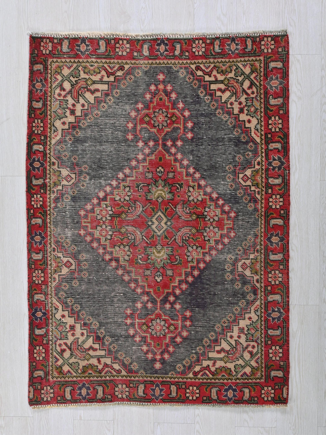 a red and blue oriental rug on a white wall