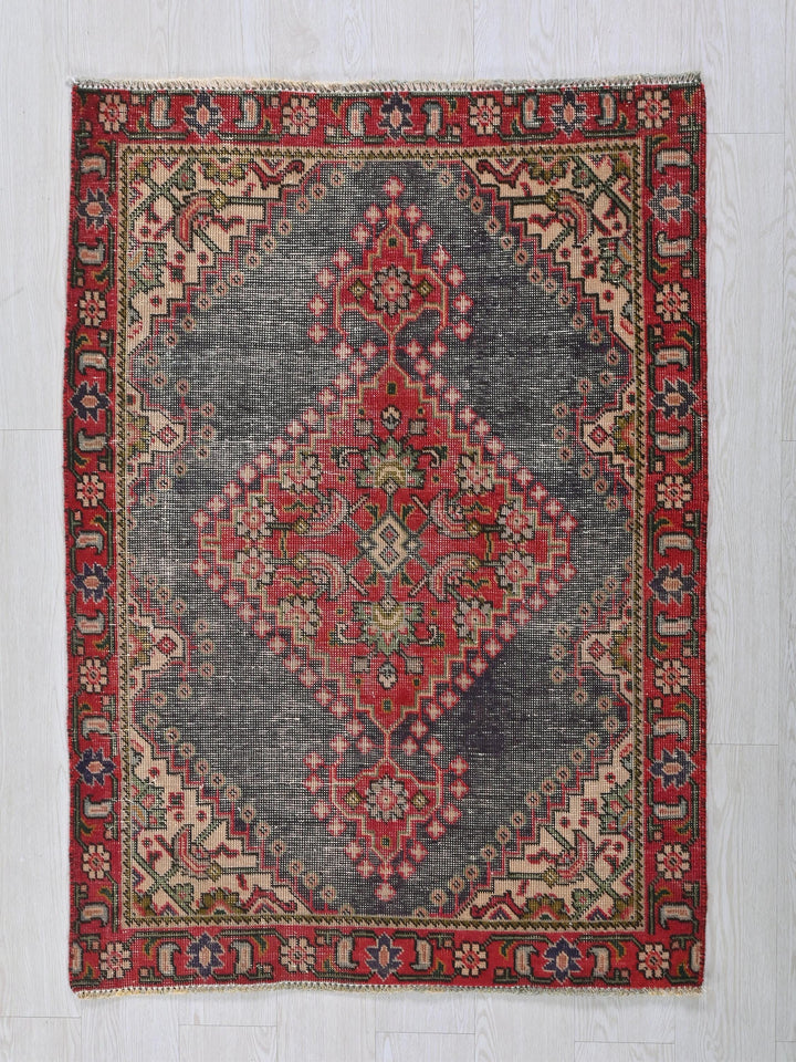 a red and blue oriental rug on a white wall