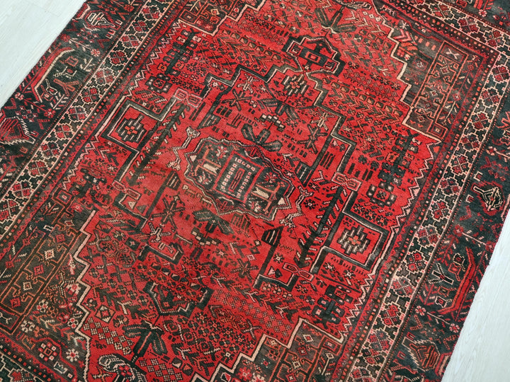 a red rug with a black border on a white floor