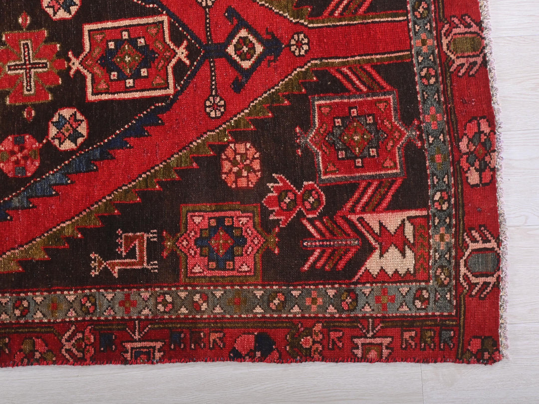 a red and black oriental rug on a white floor