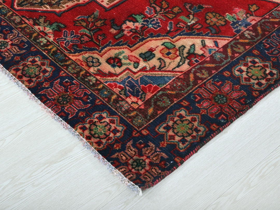 a red and blue oriental rug on a white floor