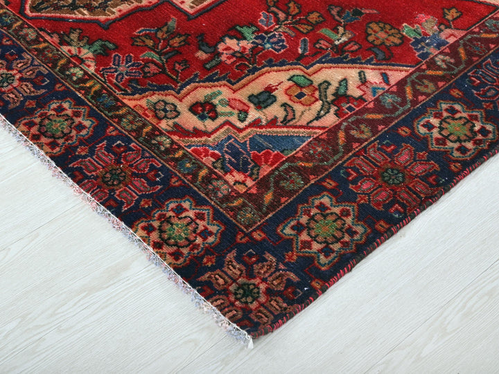 a red and blue oriental rug on a white floor
