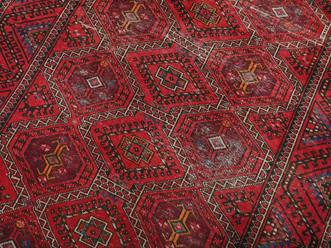 a red oriental rug with a diamond pattern