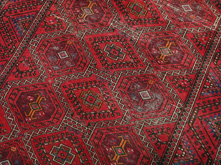 a red oriental rug with a diamond pattern