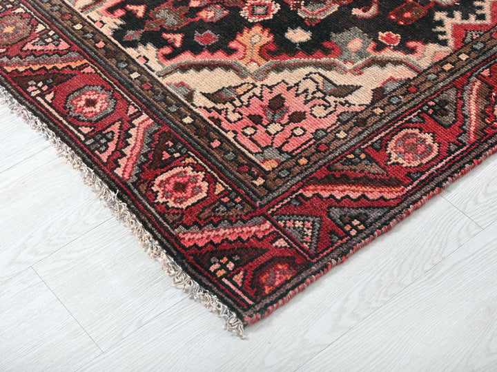 a red and black oriental rug on a white floor