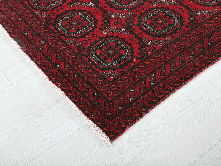 a close up of a red rug on a white floor
