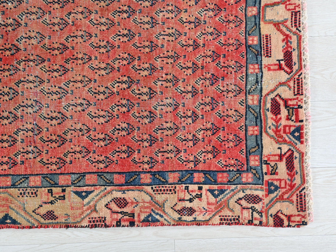 a red rug with a blue border on a white floor