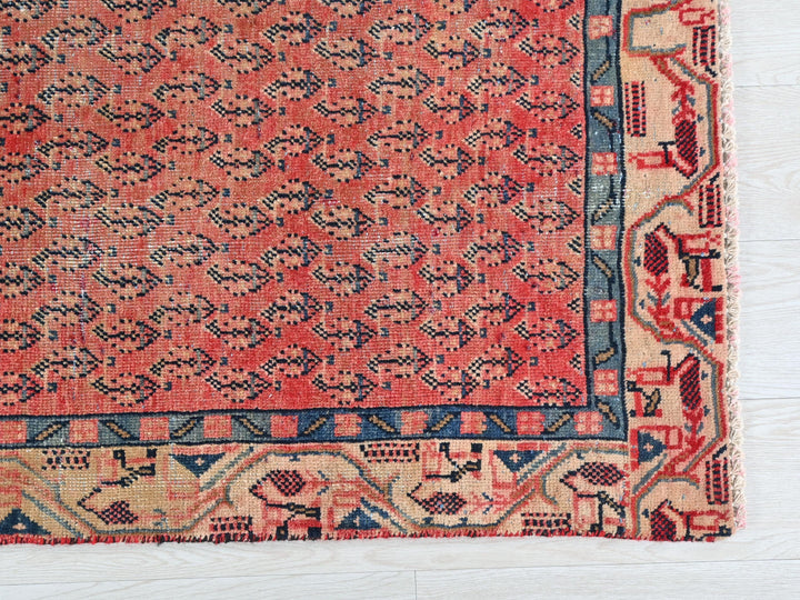 a red rug with a blue border on a white floor