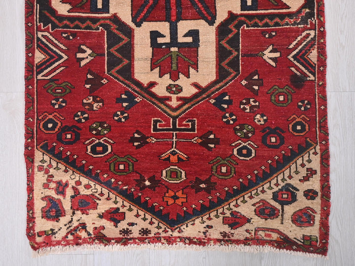 a red rug with a design on the middle of it