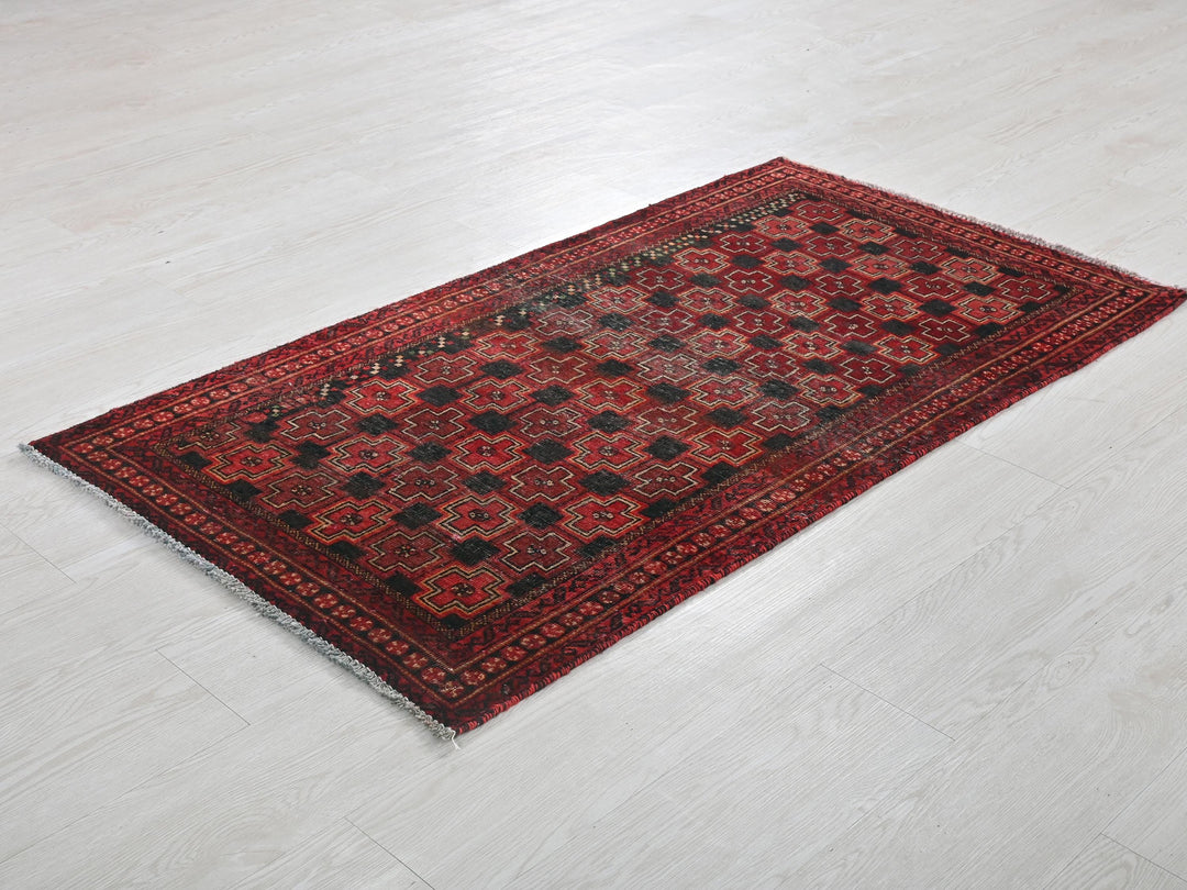 a red and black rug on a white floor