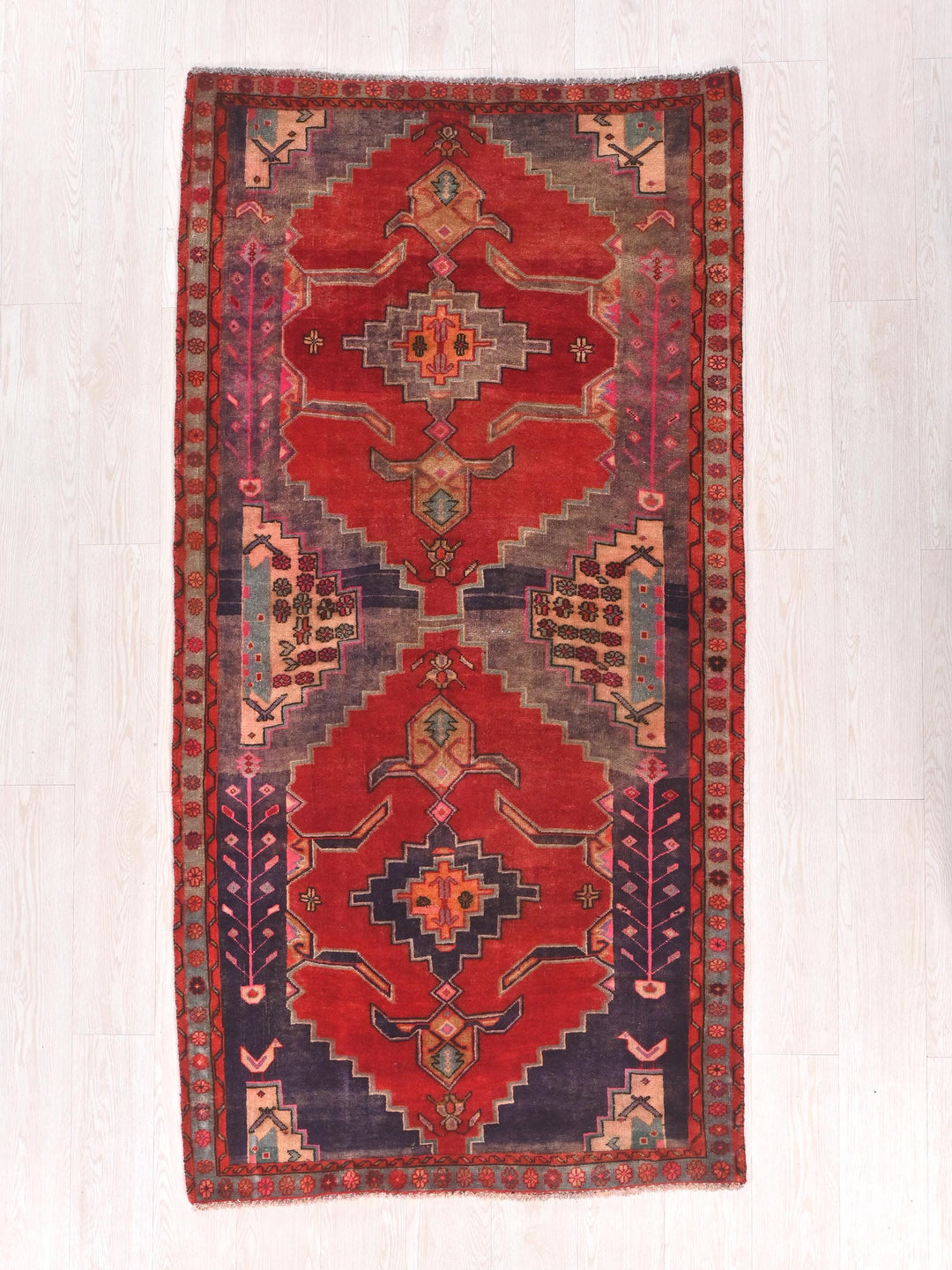 a red rug with a design on the middle of it