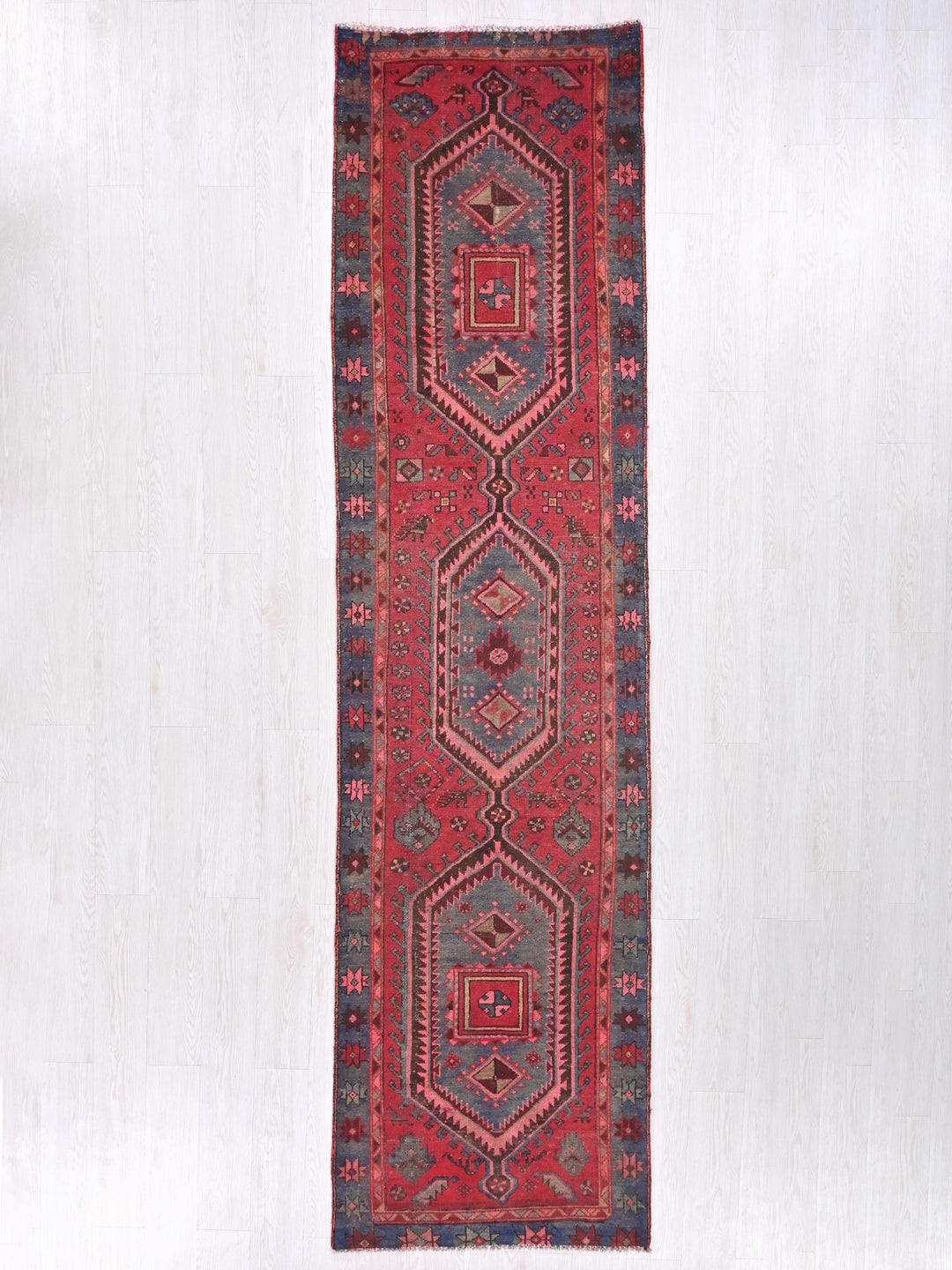 a red rug hanging on a white wall
