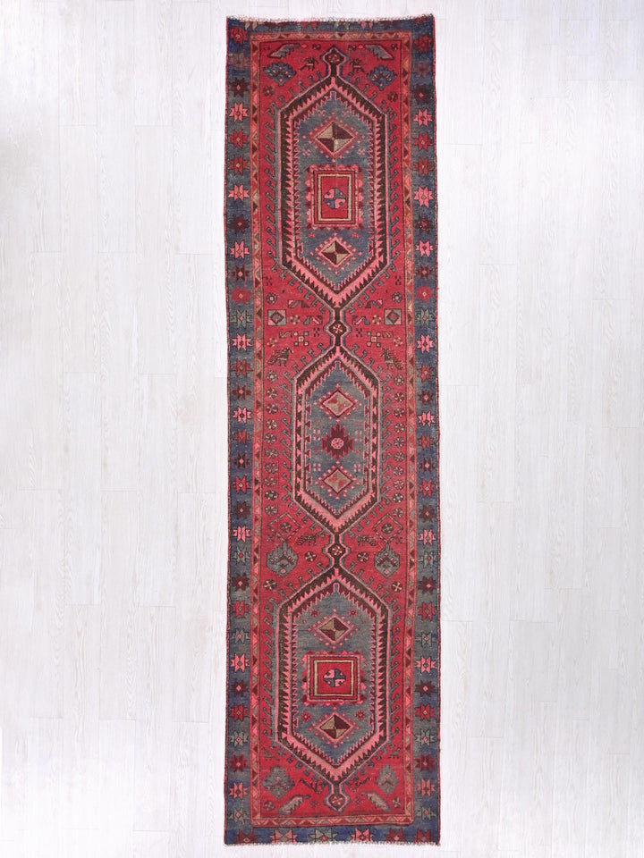 a red rug hanging on a white wall