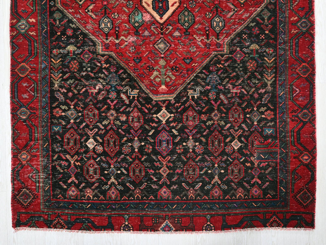 a red and black rug with a design on it