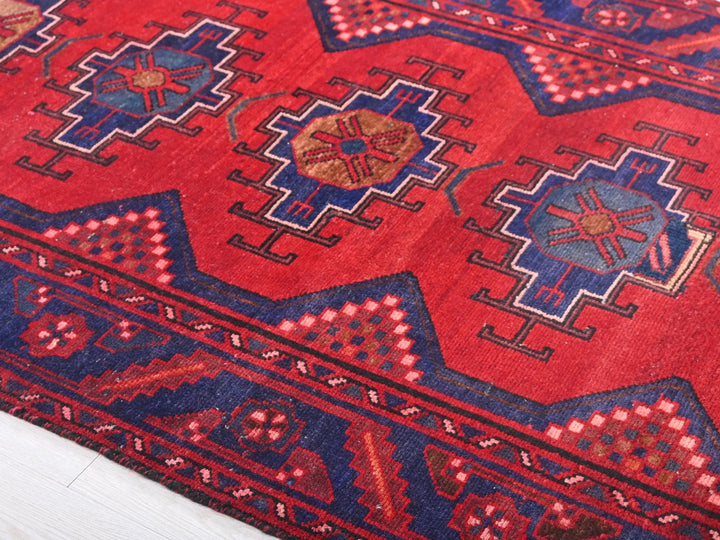 a red rug with blue and red designs on it