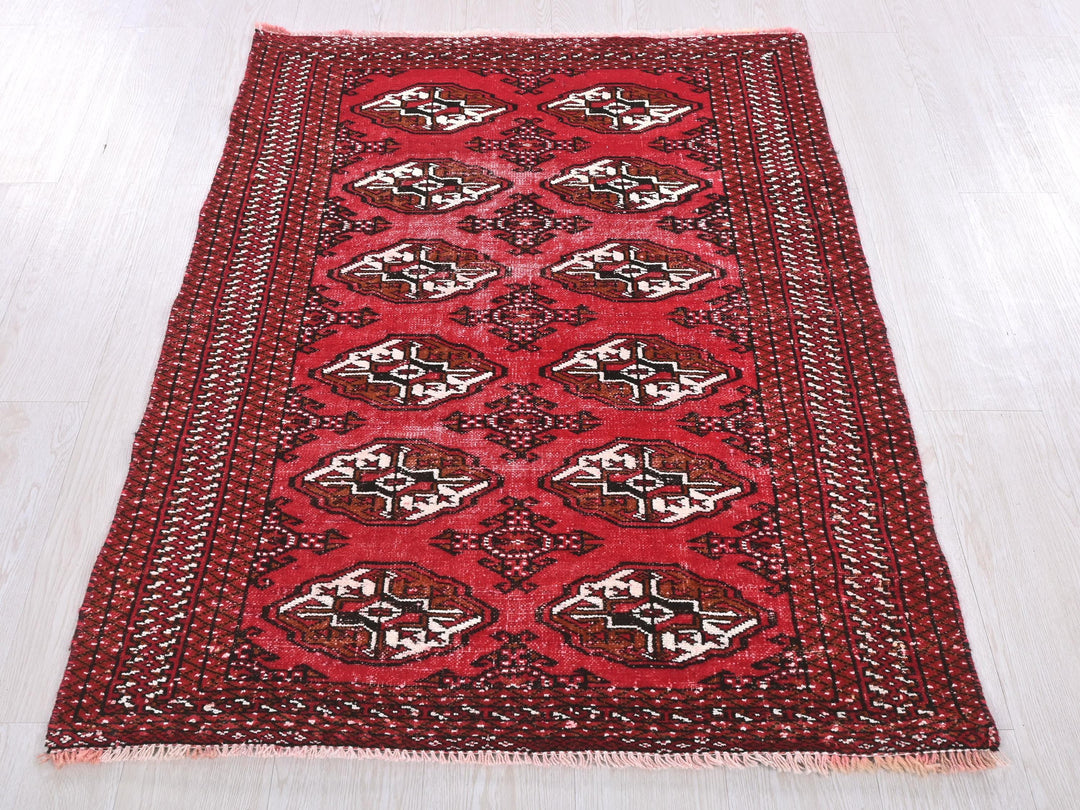a red and black rug on a white floor