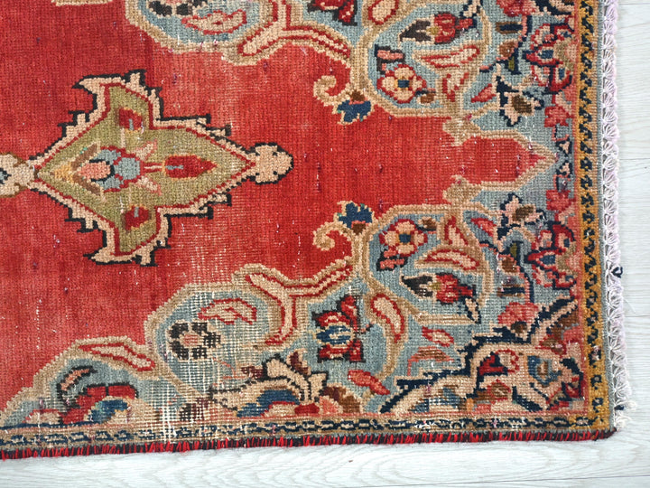 a red rug with a floral design on it