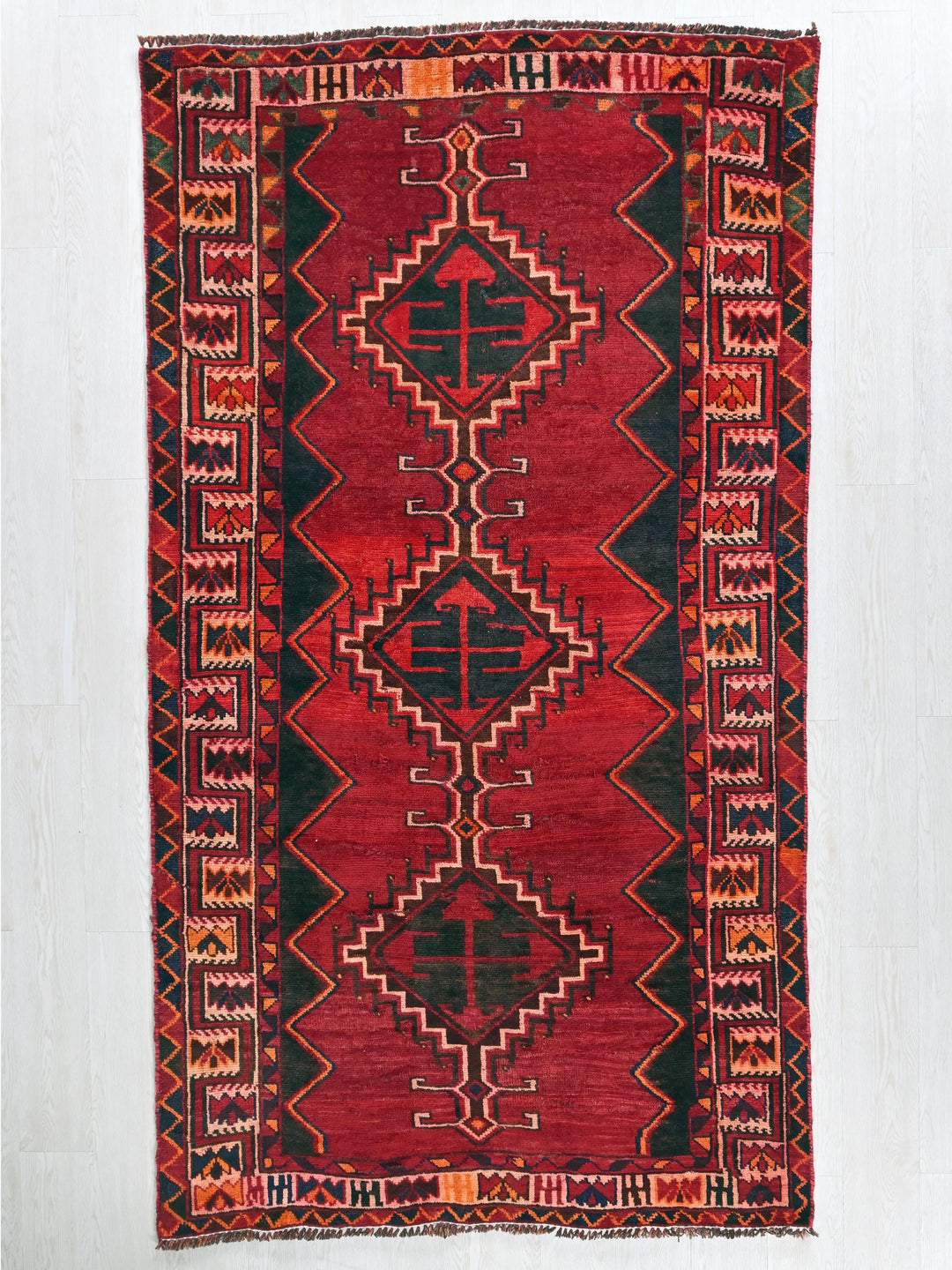 a red and black rug with a design on it