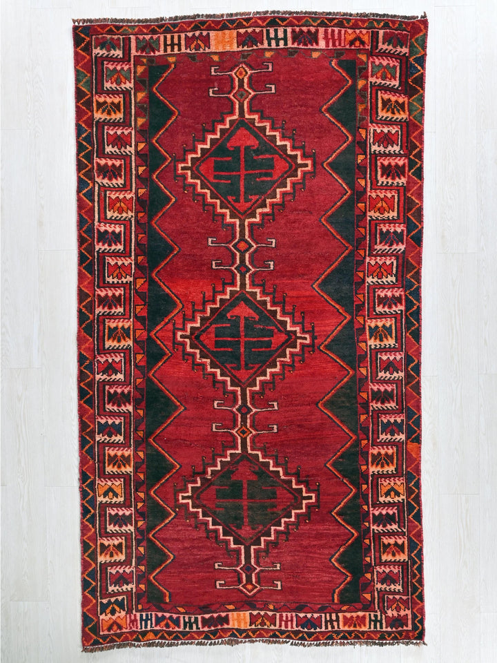 a red and black rug with a design on it