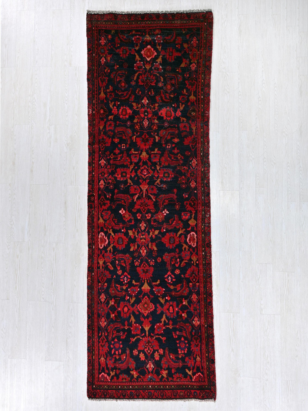 a red and black rug hanging on a wall