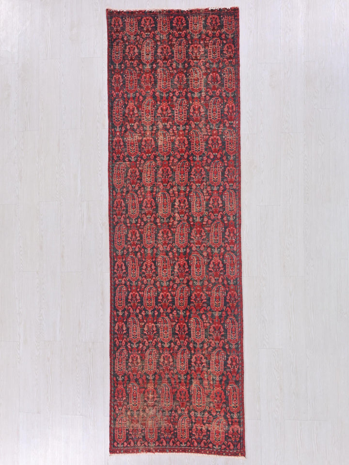a red and black rug on a white floor