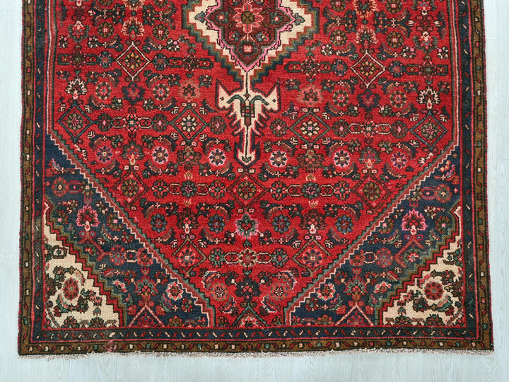 a red rug with a floral design on it