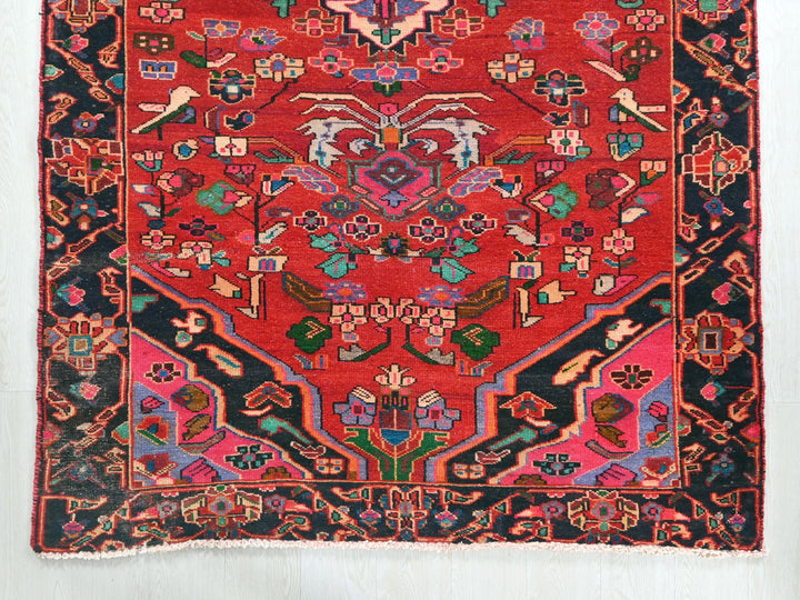 a red rug with a design on the middle of it