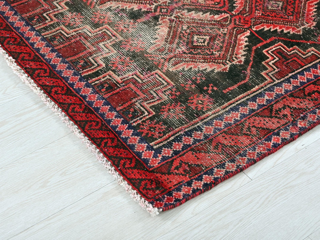 a red and black oriental rug on a white floor