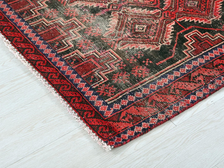 a red and black oriental rug on a white floor