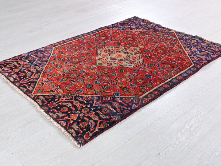 a red and blue rug on a white floor