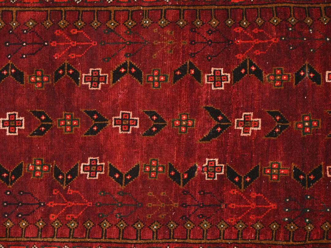 a close up of a red rug with black and white designs
