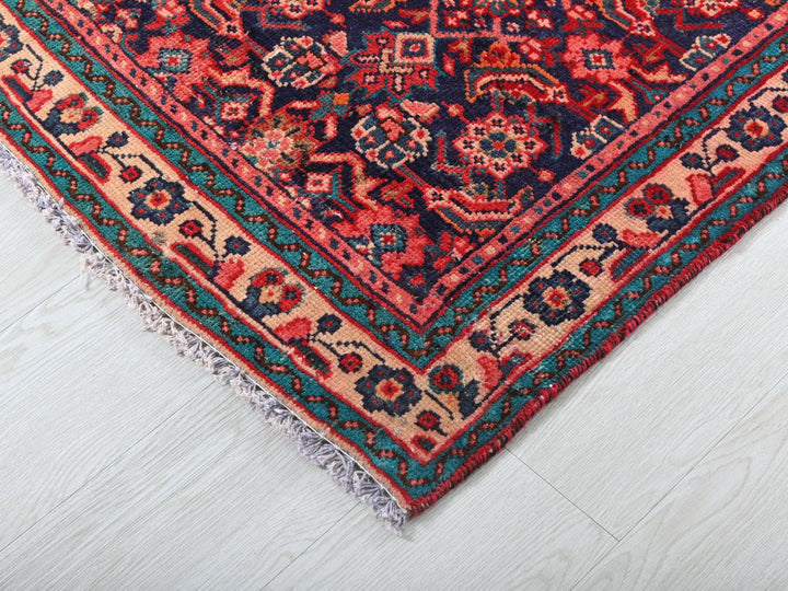 a red and blue oriental rug on a white floor