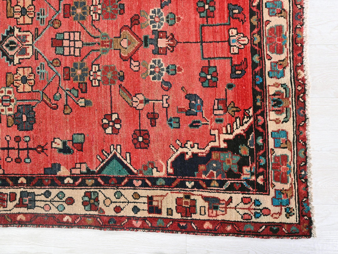 a red rug with a design on the middle of it