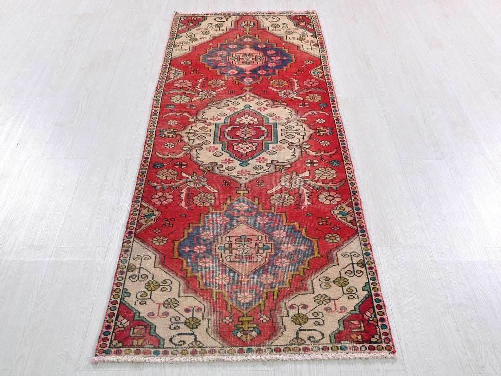 a red and blue rug on a white floor