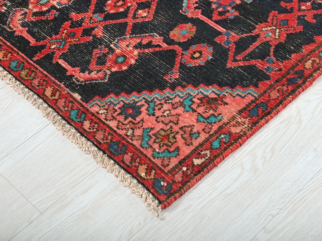 a red and black oriental rug on a white floor