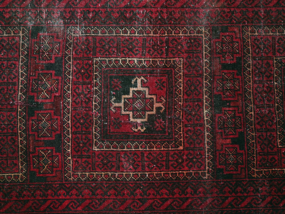 a red and black rug with a cross on it
