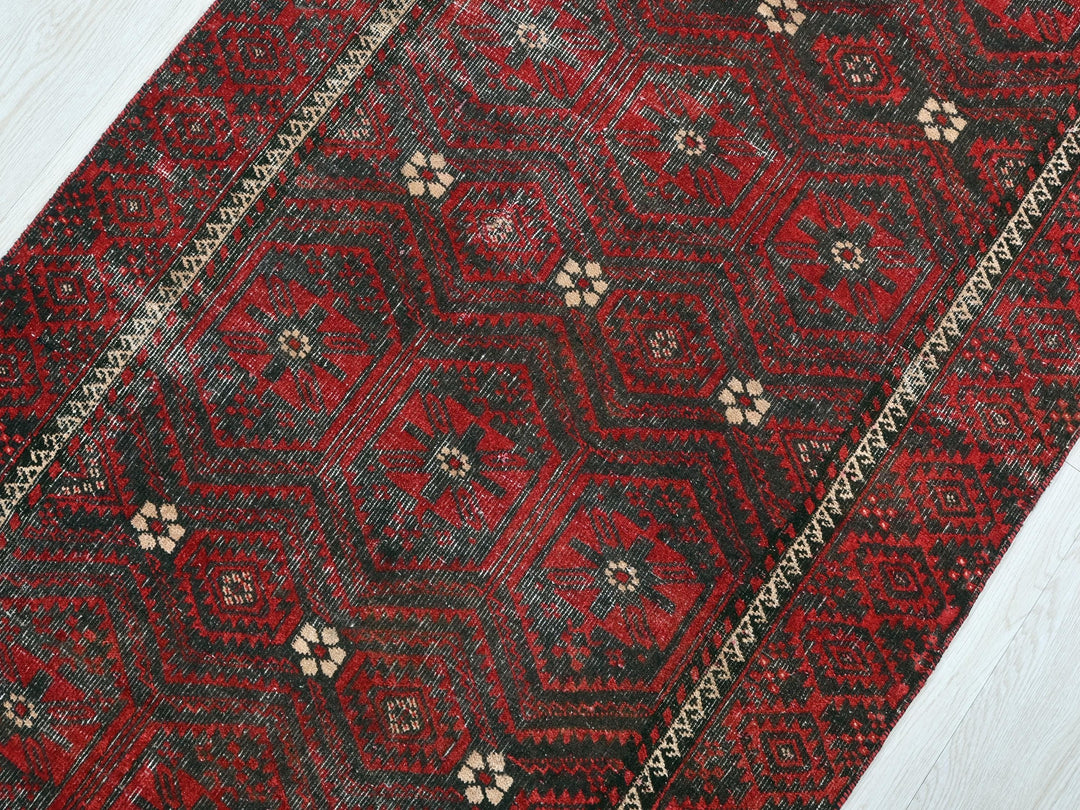 a red rug on a white wooden floor