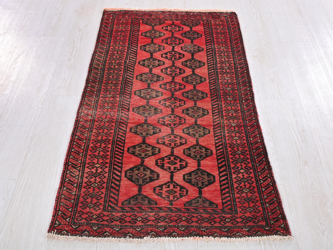 a red and black rug on a white floor