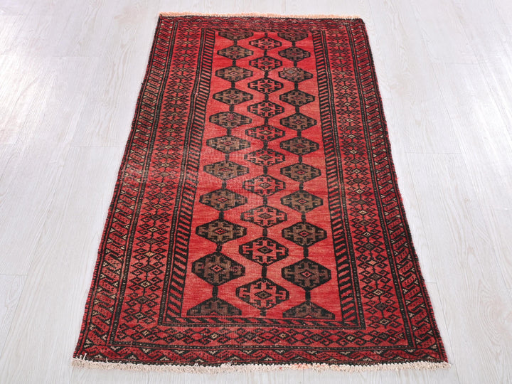 a red and black rug on a white floor