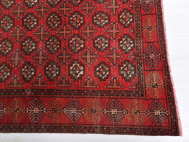 a red rug with a design of crosses on it