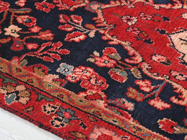 a red and blue oriental rug on a white wooden floor