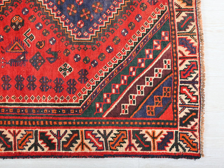 a red rug with a design on the middle of it