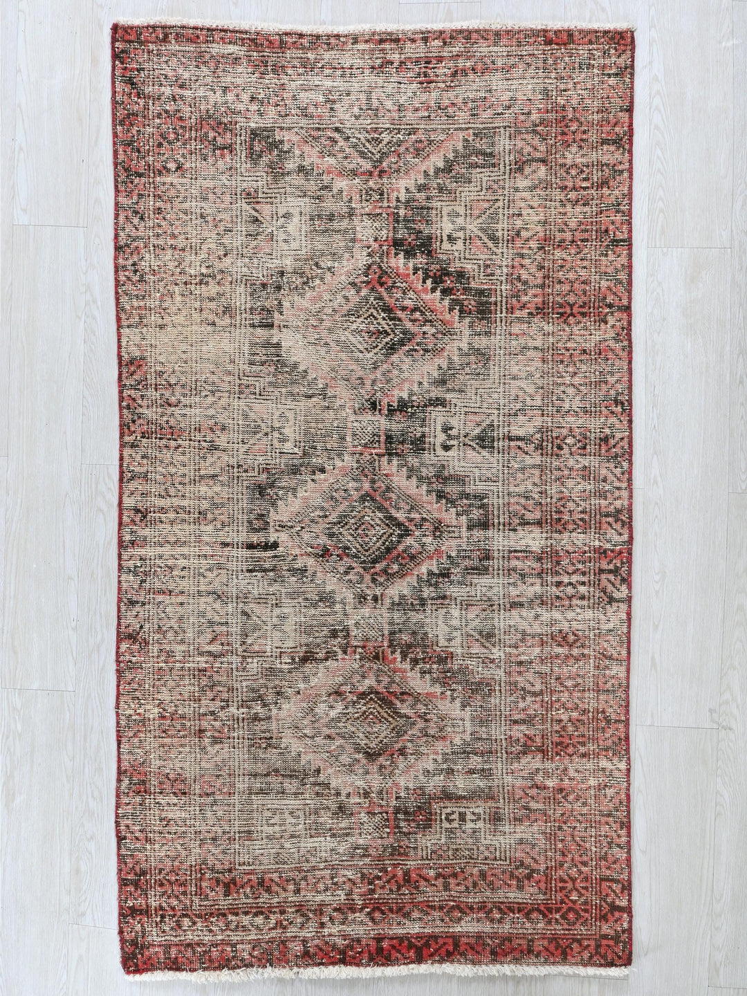 a red and beige rug on a white floor