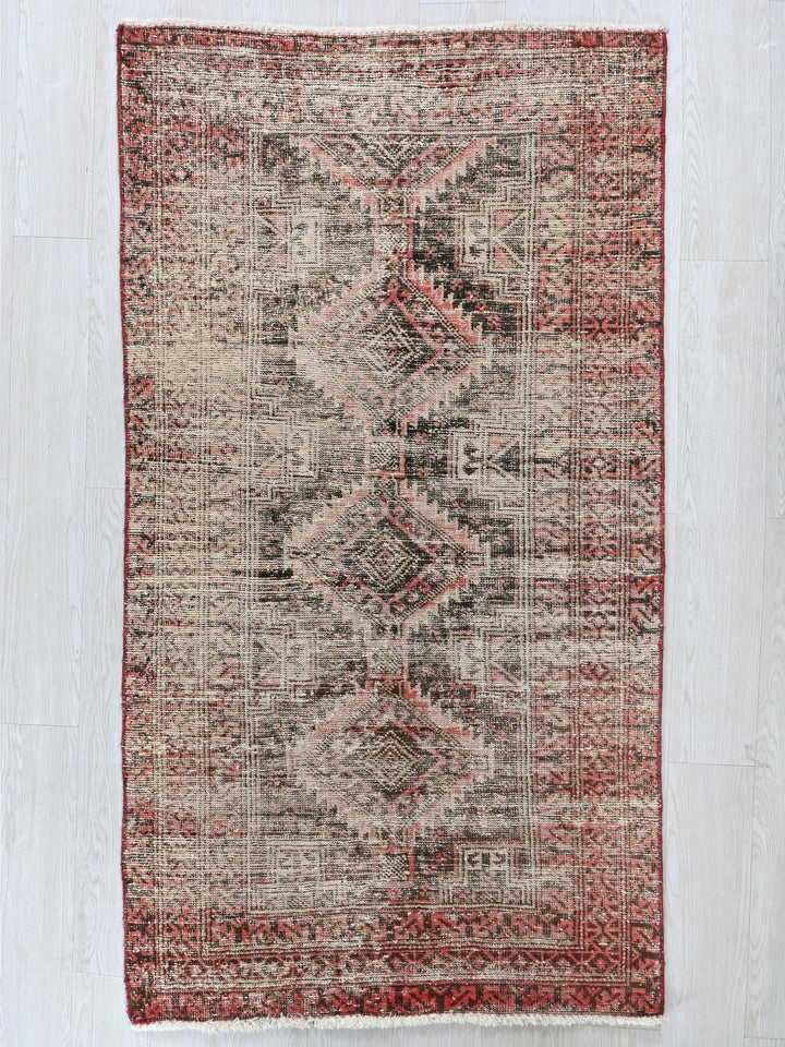 a red and beige rug on a white floor